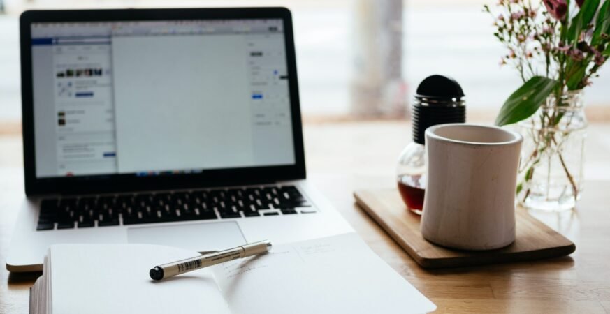 Macbook pro near white open book scaled