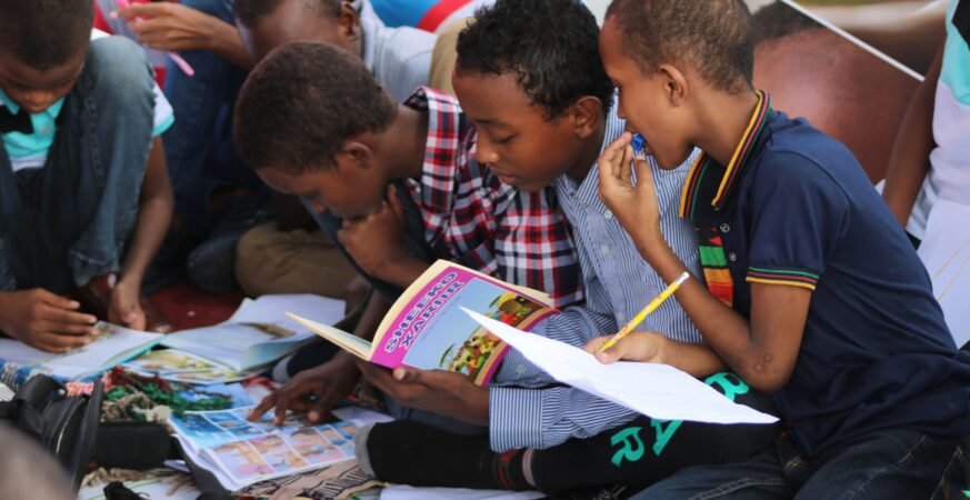 Boy in blue and white plaid shirt reading book scaled